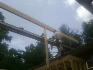 Carpenter setting a ridge beam over a new addition frame — Ice Dam Removal by Roofing Brothers in Mays