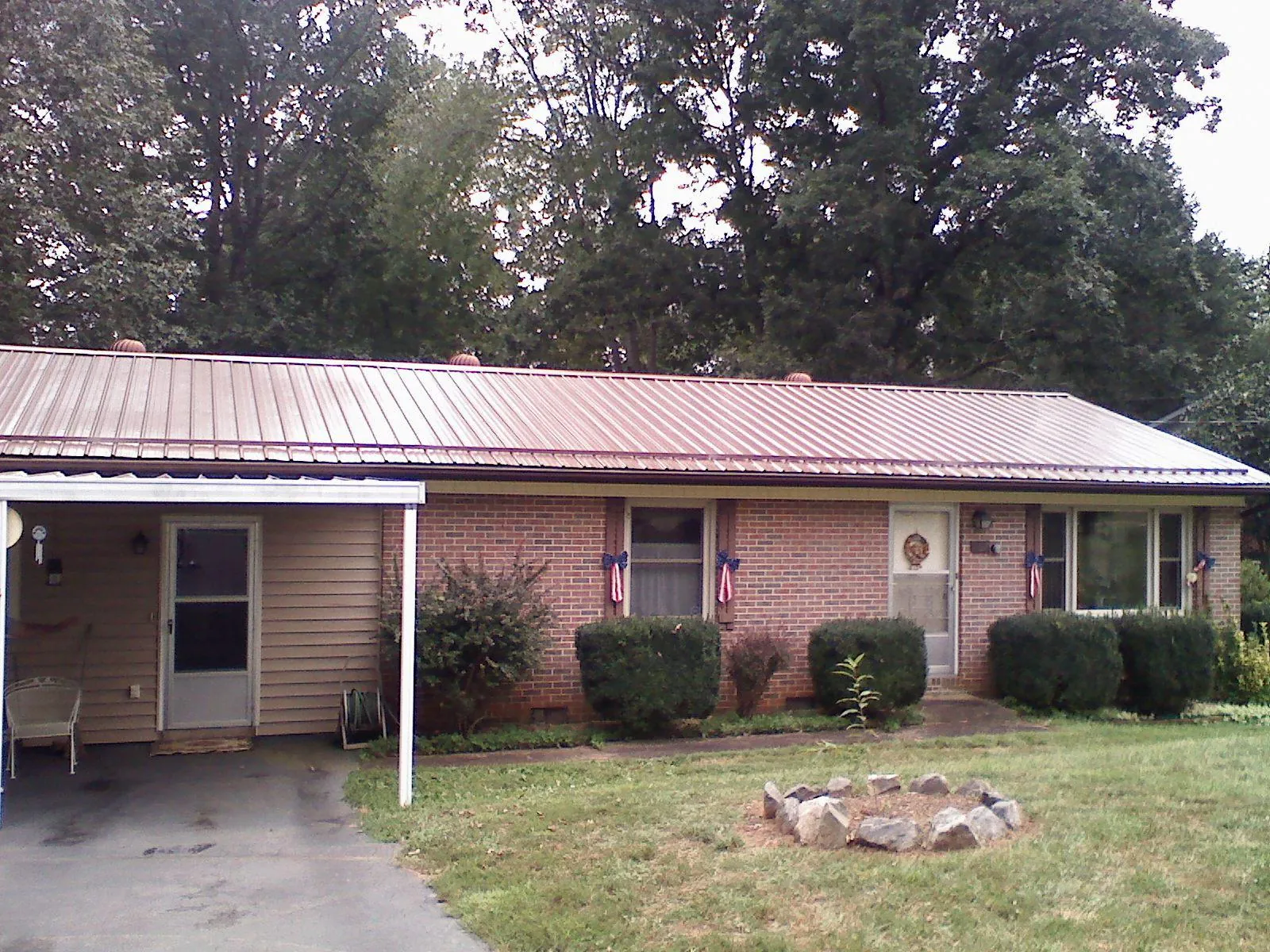Bronze metal roof and carport on a brick ranch home — Roof Repair work by our crew in Mays